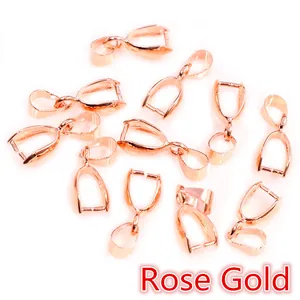 Close-up of rose gold plated pinch bails for pendants scattered on white background