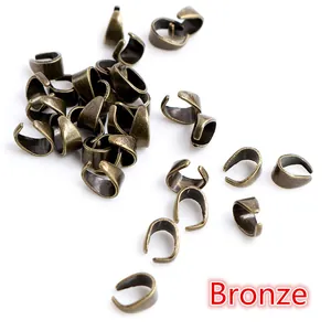 Vista macro de 50 enganches de bronce vintage para colgantes de joyería DIY