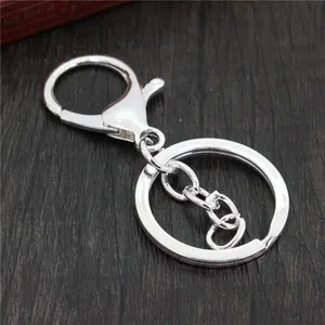 Polished silver metal lobster clasp keychain with flat ring and chain on a wooden desk