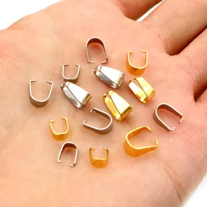 Hand holding stainless steel pinch bails in gold and silver for DIY jewelry making