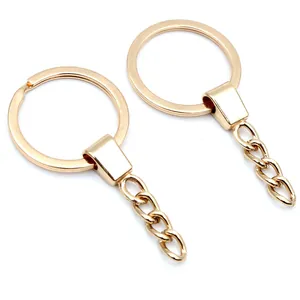 Vista dettagliata di due portachiavi in oro con catene corte a tre maglie metalliche