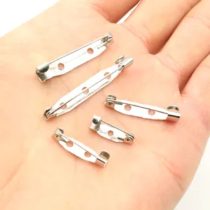DIY silver metal brooch safety pins with holes in 5 sizes shown in a person's hand