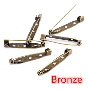 Macro view of bronze safety pins with 3 holes for DIY jewelry and brooch making