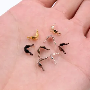 Assorted DIY jewelry clasp endings in multiple metallic colors held in hand for scale