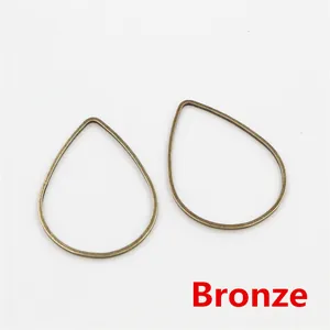 Detalle de colgantes de pendientes de gota huecos en bronce para creación de joyas DIY