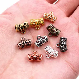 Close-up of hollow alloy bead connectors in multiple metallic finishes on hand