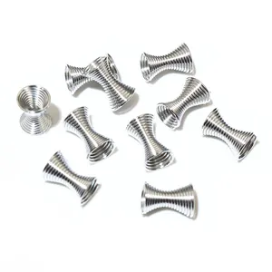 Makro-Detail von silbernen Spiralfeder-Perlenkappen und Abstandhaltern für DIY-Schmuck