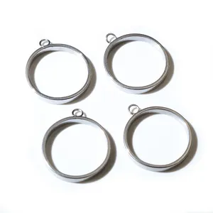Close-up van vier gepolijste roestvrijstalen frames voor DIY sieraden en hangers