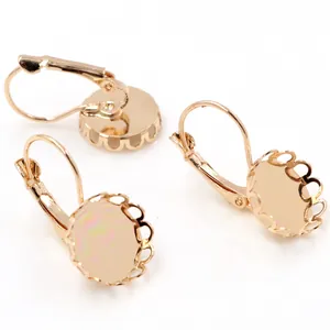 Detalle de ganchos de oreja dorados con bases redondas de encaje para creación de joyas
