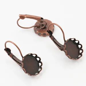 Detalle macro de pendientes de cobre antiguo con base de encaje para joyería artesanal