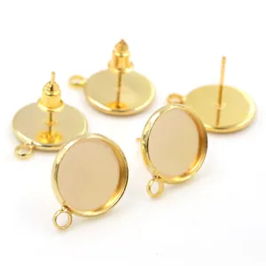 Macro shot of gold-plated earring studs with round bezels and small hanging loops