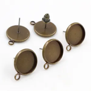 Detailed view of 5 antique bronze earring studs with round bases and hanging loops