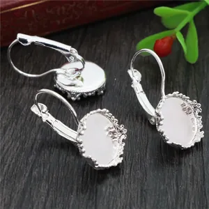 Detalle de bases de pendientes de 12mm plateadas con borde de encaje para joyería DIY