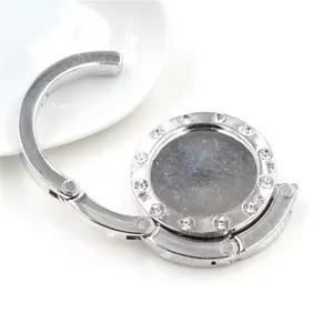 Accroche-sac pliable portable en métal argenté avec des strass étincelants