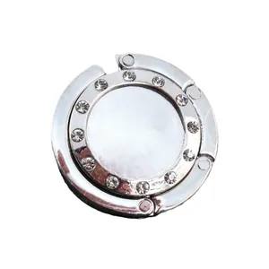 Accroche-sac pliable en métal argenté orné de onze strass brillants pour table