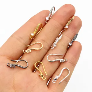 Zircon-studded copper DIY earring hooks in gold, silver, and bronze held by hand