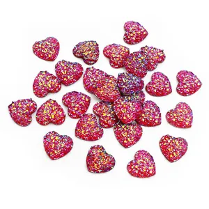 Vue macro de breloques cœur scintillantes de 12 mm avec paillettes magenta pour bijoux