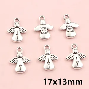Detalle de colgantes de ángel en plata antigua con alas y corazón para joyería artesanal