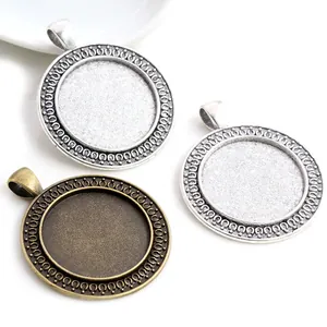 Macro detail of 25mm round alloy pendant trays with embossed patterns in silver and bronze