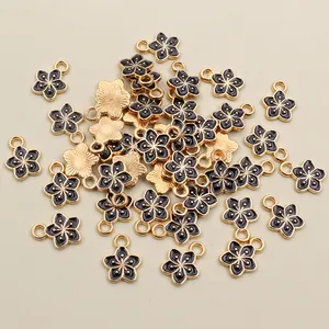 Macro shot of 11x9mm black drip oil flower charms with gold edges for DIY jewelry