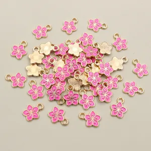 Detail view of pink enamel flower charms with gold edges for DIY jewelry making