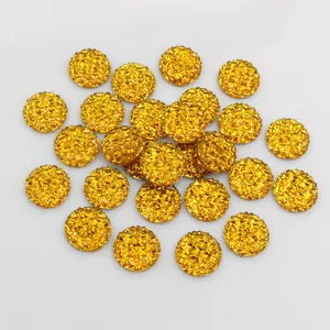 Macro shot of 12mm golden resin pineapple cabochons with faceted druzy surface for DIY crafts