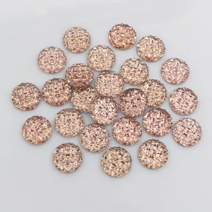 Detailed macro view of 12mm champagne gold round resin rhinestones with faceted texture