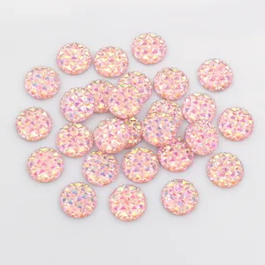 Macro view of 12mm peach pink faceted resin cabochon with shimmering texture