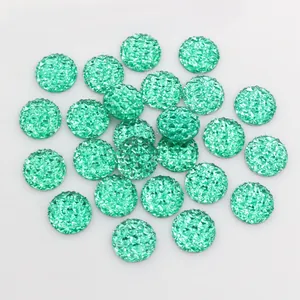 Detailed view of 12mm mint green resin druzy cabochons with sparkling faceted texture