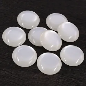 Cabochon rond en résine blanche de 25mm avec effet oeil de chat sur fond en bois