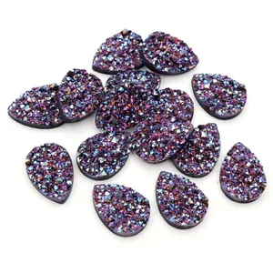 Détail macro de cabochons en résine druzy irisés en forme de goutte et texture cristal