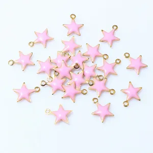 Macro detail of pink enamel star charms with gold-plated base for DIY jewelry making