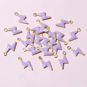 Macro detail of 20 lightning bolt enamel charms for DIY jewelry making in purple and gold