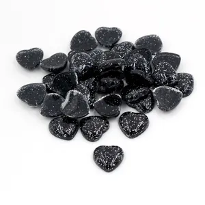Vue macro de boutons en résine noire en forme de cœur avec paillettes blanches