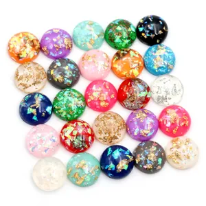 Bunte 8-12mm Harz-Cabochons mit glitzernder Goldfolie und Pailletten auf weißem Hintergrund
