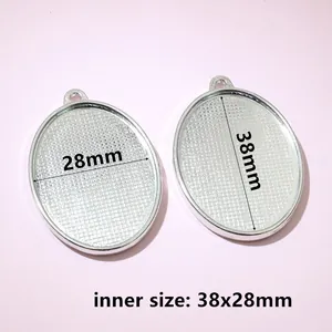 Detailed view of silver oval alloy pendant base with grid texture, inner size 38x28mm
