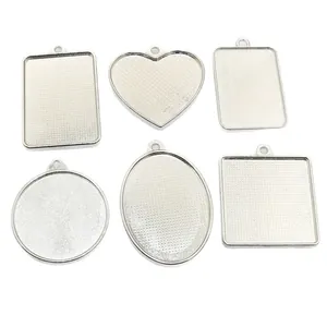 Silver alloy jewelry pendant trays in heart, square, and oval shapes for DIY crafts