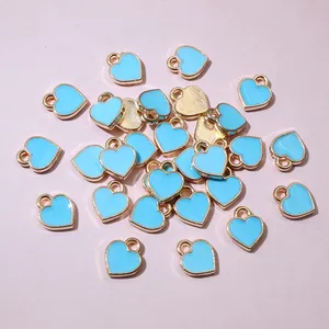 Close-up of mini light blue heart charms with gold edges for DIY jewelry making