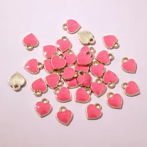 Detailed close-up of pink heart enamel charms with gold-plated edges for DIY jewelry