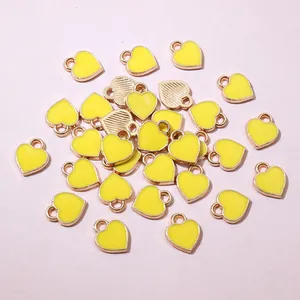 Close-up of mini yellow heart charms with gold metal edges and DIY hanging loops