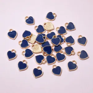 Macro shot of mini heart charms with deep blue enamel surface and gold textured back