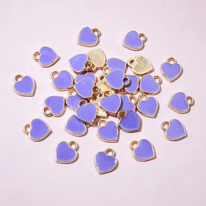 Close-up of mini lavender enamel heart charms with gold metal frame for jewelry making