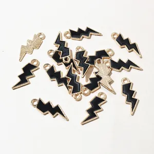 Macro detail of lightning bolt charms with black enamel and gold alloy finish for DIY jewelry