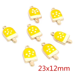 Detail view of yellow alloy ice cream pendants with white dots for DIY jewelry making