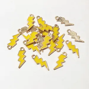 Macro detail of lightning bolt alloy charms with yellow enamel and gold-plated finish