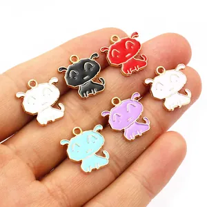 Hand holding colorful cartoon puppy alloy charms for DIY jewelry making and crafts