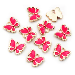 Detailansicht von 10 rosa Emaille-Schmetterlingsanhängern mit Goldlegierung und Ösen