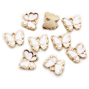 Makroaufnahme von 10x13mm Gold-Schmetterling-Anhängern mit weißem Emaille für DIY-Schmuck