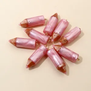 Macro view of 9 resin pencil pendants with pearl pink finish and gold metal loops