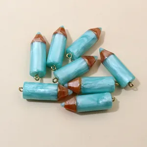 Flat lay of blue marble texture resin pencil charms with golden eyelet hooks